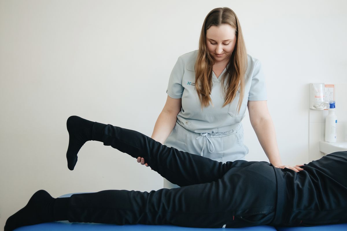 Physiotherapist assisting a patient during treatment
